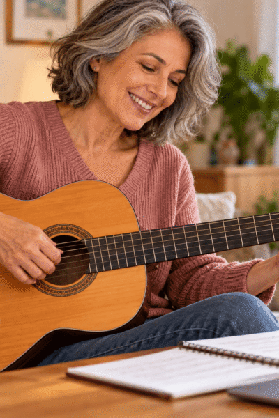 Mulher madura tocando violao em casa
